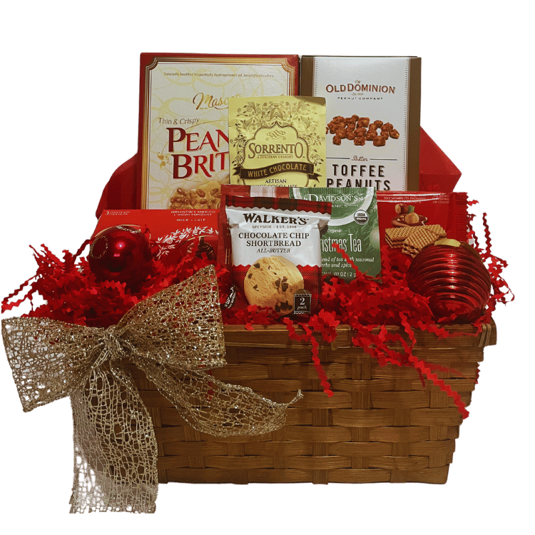 Elegant red holiday-themed gift basket filled with gourmet treats including peanut brittle, toffee peanuts, white chocolate cocoa mix, Lindor chocolate balls, chocolate chip shortbread cookies, hazelnut milk chocolate wafers, and holiday-flavoured teas.