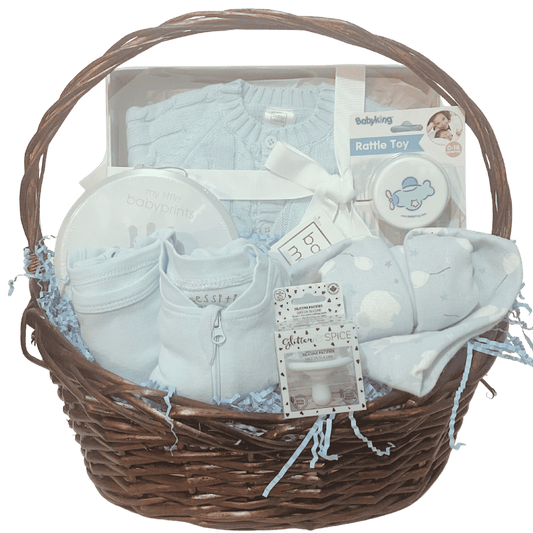 Baby Essentials Premium gift basket in blue, unwrapped, featuring baby bath items, blanket and grooming accessories arranged in a keepsake basket