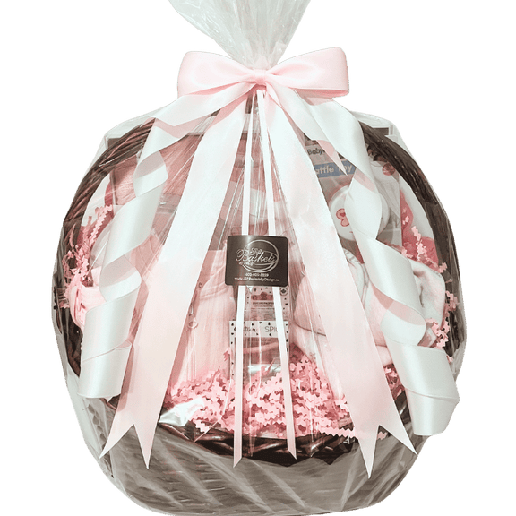 Baby Essentials Premium gift basket in pink, wrapped in cellophane with ribbon, featuring baby bath items, blanket and grooming accessories in a keepsake basket