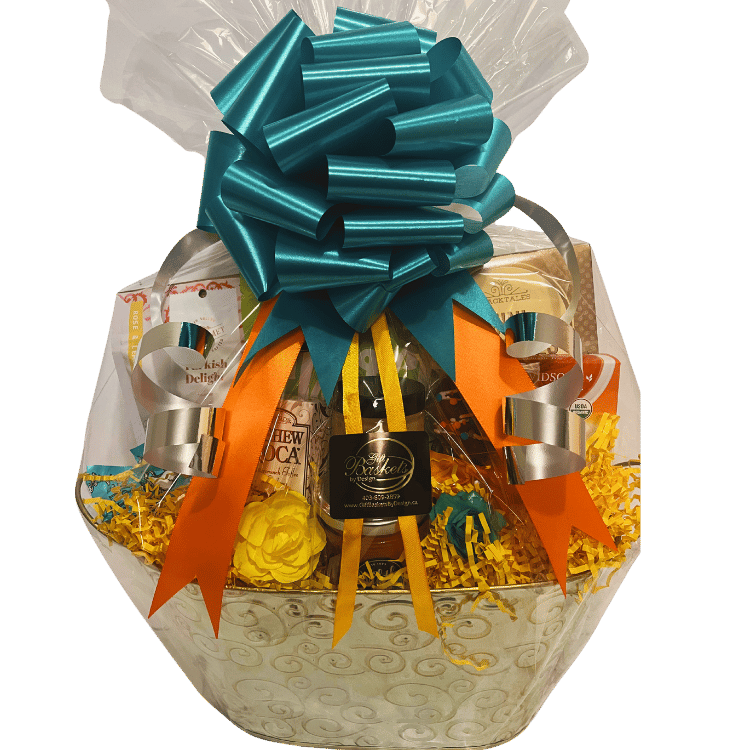 A gift basket containing a variety of food items including roasted red pepper and feta dip, artisan breadsticks, mini pretzels, gourmet mixed nuts, Turkish delight, handmade milk chocolate shortbread, tea box, milk chocolate Oreo pop, buttercrunch toffee with cashews, and chocolate truffles, all tied together with a blue and orange ribbon.