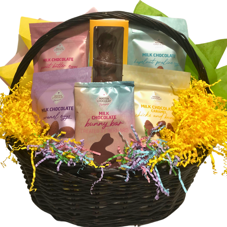 Wicker basket filled with assorted Easter chocolates in cheerful pastel wrapping.