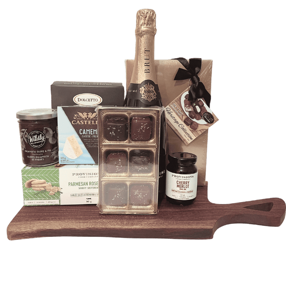 Bottle of Baron Maximilien champagne on a wooden board with Castello Camembert cheese, chocolate truffles, and cherry merlot jam.