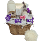 Luxurious gift basket wrapped in pink and purple, featuring Calgary-made bath products, a jar candle, assorted chocolate truffles, spa slippers, and a loofah.