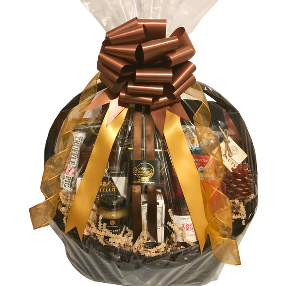 A large wicker gift basket brimming with gourmet treats, shown wrapped in cellophane with elegant gold ribbon.