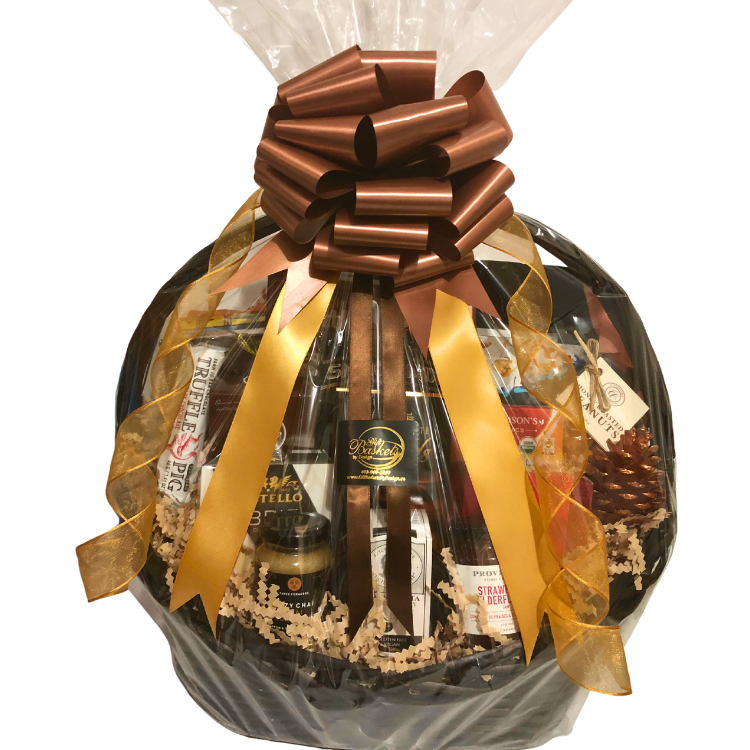 A large wicker gift basket brimming with gourmet treats, shown wrapped in cellophane with elegant gold ribbon.