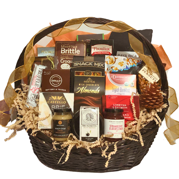 A large wicker gift basket brimming with gourmet treats, shown unwrapped to showcase artisan food items like brie, chocolates, tea, crackers, and spreads.